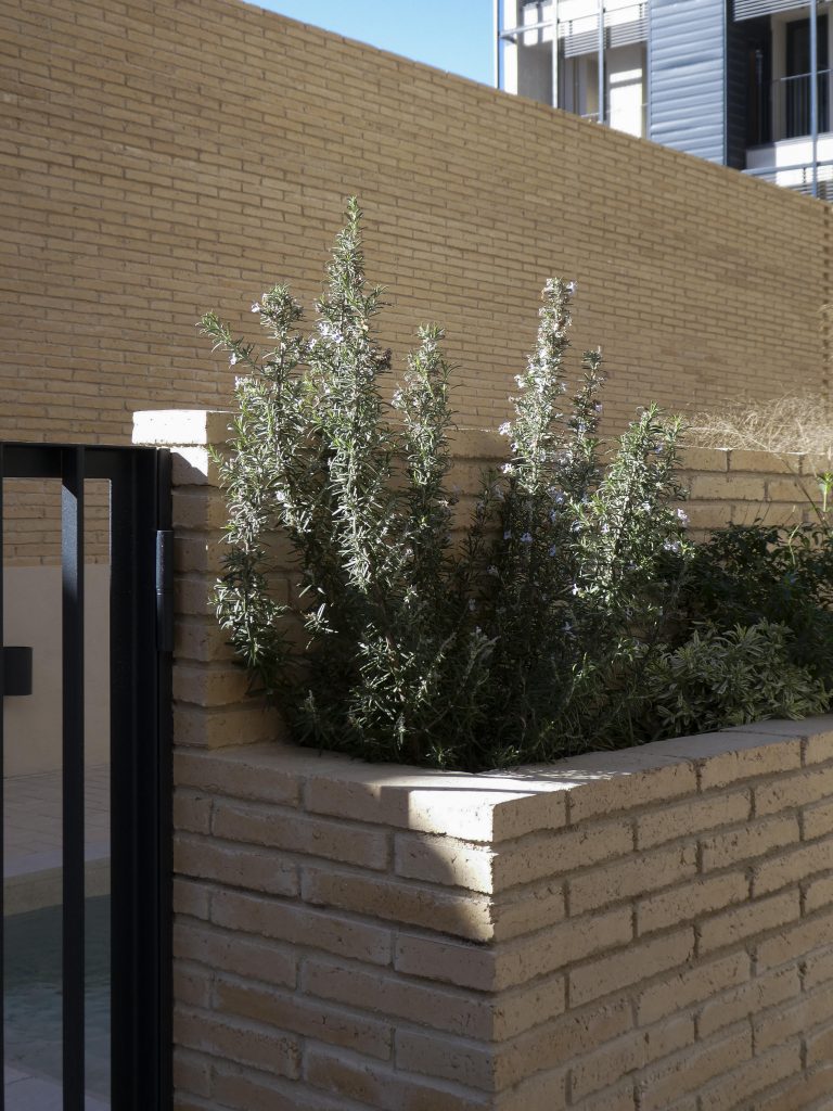 low wall from beige brick with planter