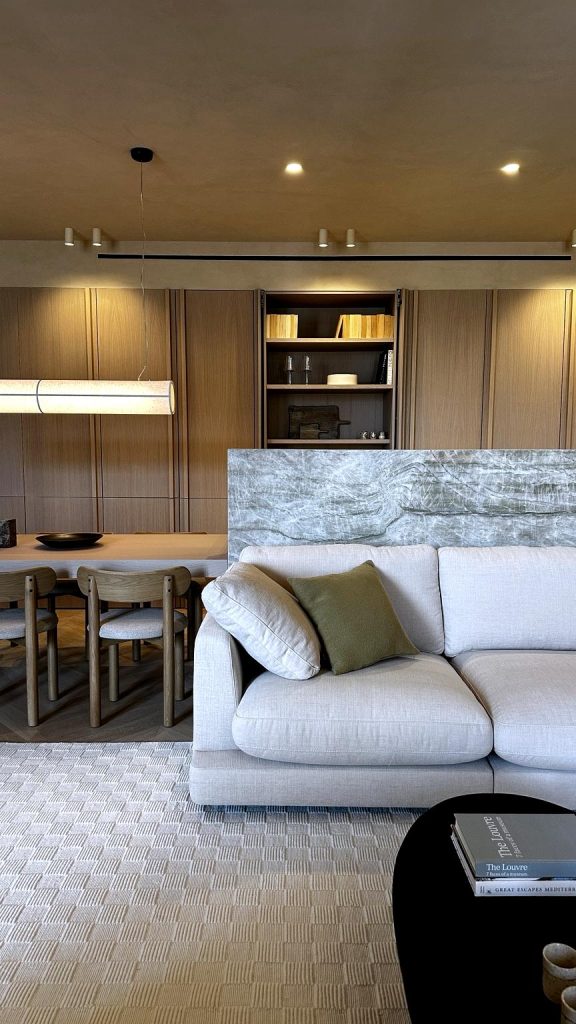 vista de la cocina des del salón, se aprecia la encimera verde de marmol taj mahal y los muebles altos de madera de roble