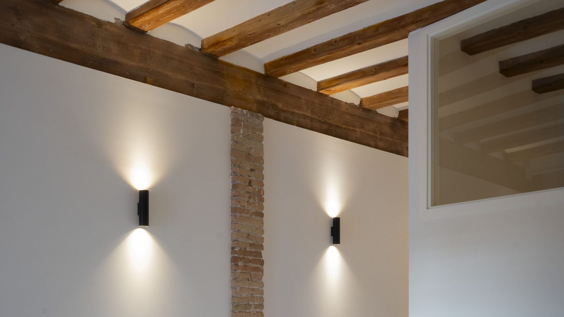 ceiling architecture with wooden beams and stone pilar and two black lights